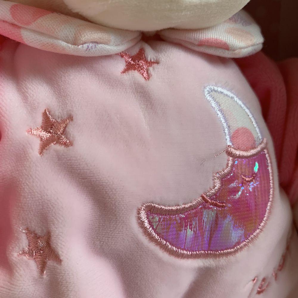 Ursuleț de pluș cu lumini și sunete, creat pentru joacă și momente de relaxare pentru copii mici.