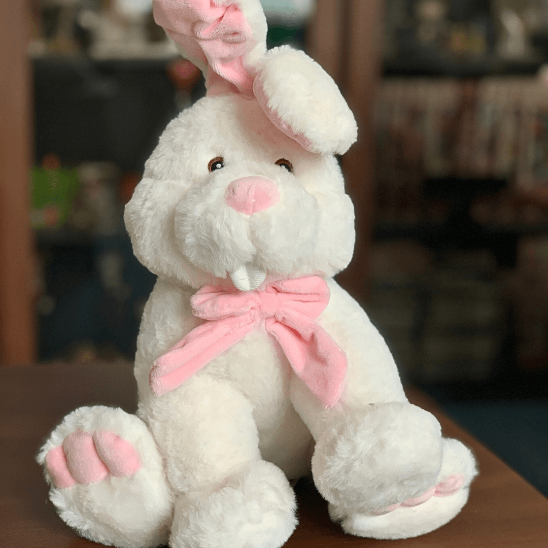 Iepuraș de pluș alb cu fundiță roz – o jucărie pufoasă și delicată, perfectă pentru a-i ajuta pe copii să adoarmă liniștiți.